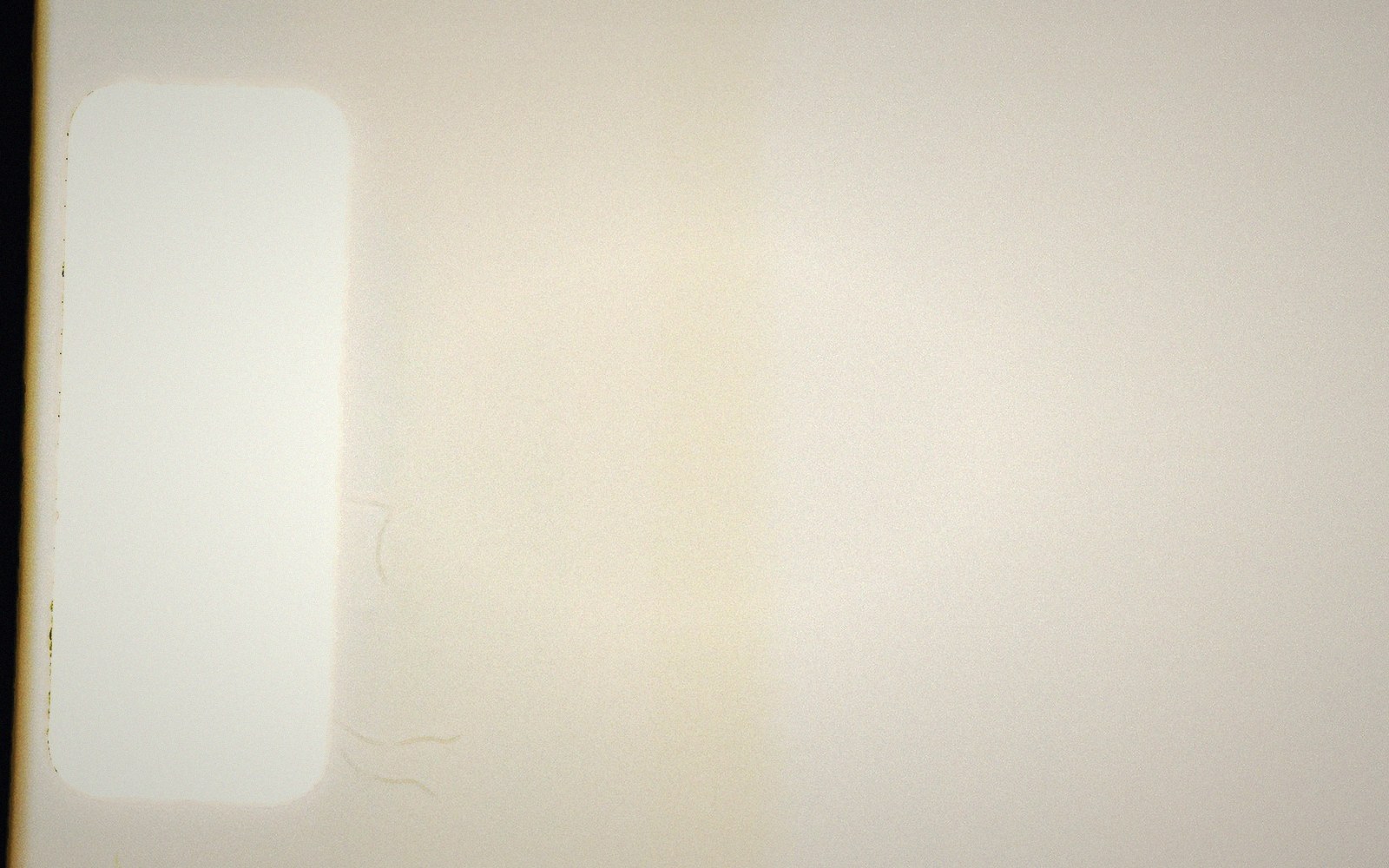 Blank cream-colored surface with a faint rectangular outline and light scratches