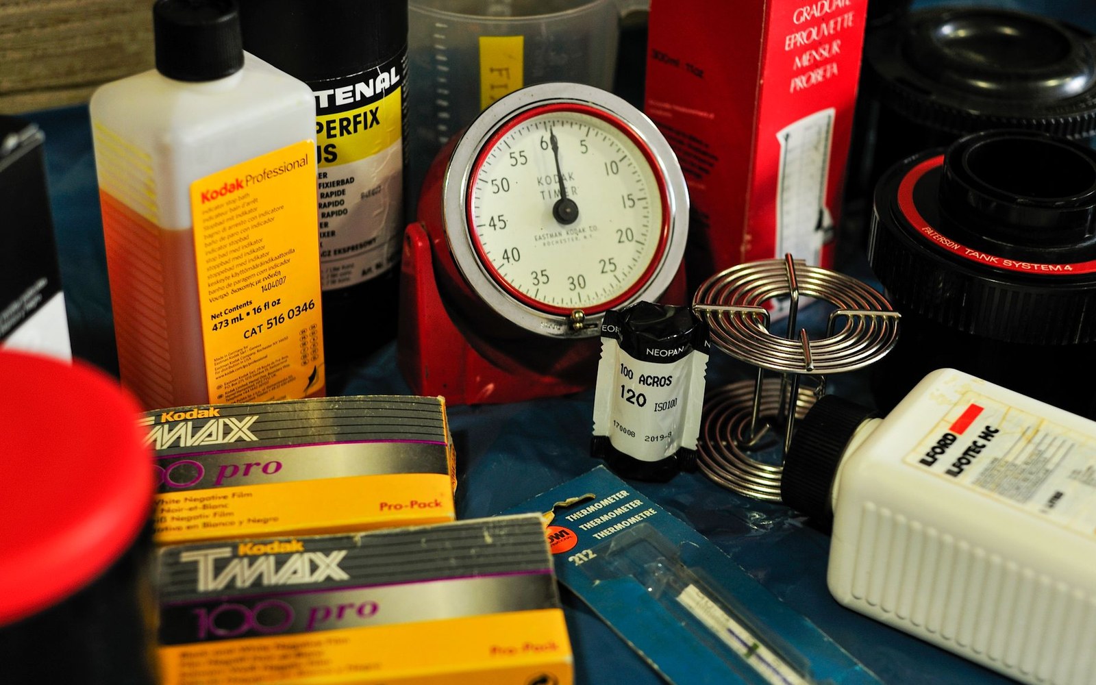 Film developing supplies including Kodak Tmax boxes, a timer, thermometer, and developing reel